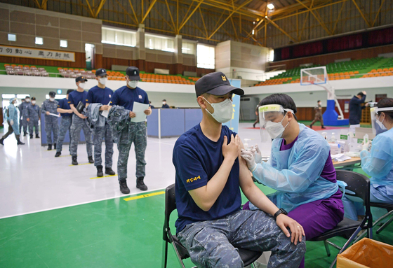 A Marine receives an AstraZeneca vaccine shot at the Jinhae Naval Base in Changwon, South Gyeongsang, on Wednesday, as the country began inoculating troops age 30 and older. No specific plan has been made for around 455,000 soldiers under the age of 30. [YONHAP]