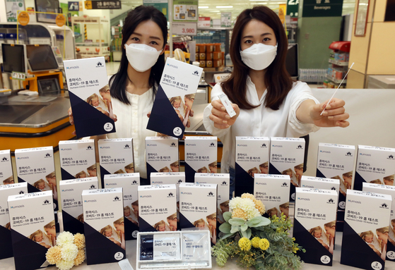 Models pose with Humasis Covid-19 test kits at Emart’s Seongsu branch in eastern Seoul on Thursday. Emart is the first discount mart in Korea selling the test kits. [YONHAP]