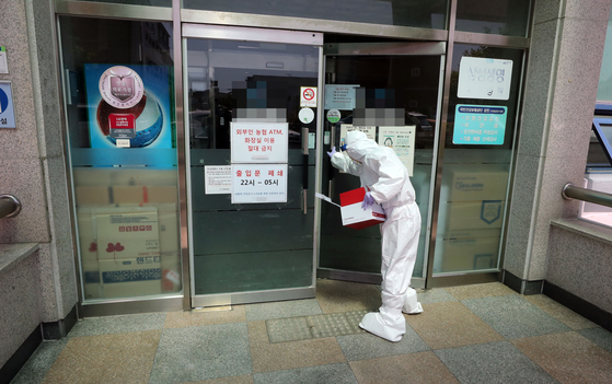A health official enters the nursing hospital in Yeosu, South Jeolla, on Sunday, where 10 patients have been newly diagnosed with Covid-19 since a caregiver was tested positive on May 8. [YONHAP]