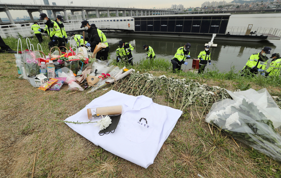 Police on Monday search for the phone of Sohn Jeong-min's friend at Banpo Han River Park, now lined with commemorative flowers. [NEWS1]