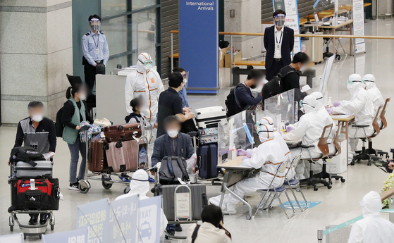 A group of some 170 Koreans arrive from India, a virus hotspot, on a special fl ight Tuesday morning at Incheon International Airport. [NEWS1]