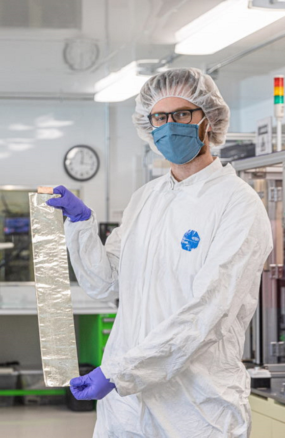 A researcher at SolidEnergy Systems holds foil used for lithium metal batteries. [SK INC.]