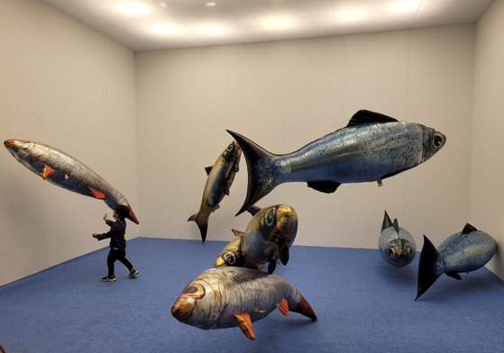 A child plays with fish balloons, which are an artwork by the world-famous French artist Philippe Parreno titled “My Room is Another Fish Bowl,” at the booth of the London-based gallery Pilar Corrias during the Art Busan fair’s VIP preview on Thursday. The booth is part of the special exhibition sections of the fair, which was held at the Bexco convention center in the port city from Thursday to Sunday. [MOON SO-YOUNG]