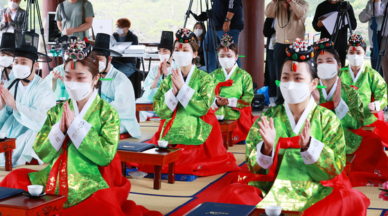 Young people dressed in hanbok, or traditional Korean attire, who have reached the age of adulthood, clap during a ceremony to mark the 49th anniversary of the Coming-of-age Day at the Hanok Village in Jung District, central Seoul, on Monday. [NEWS1]