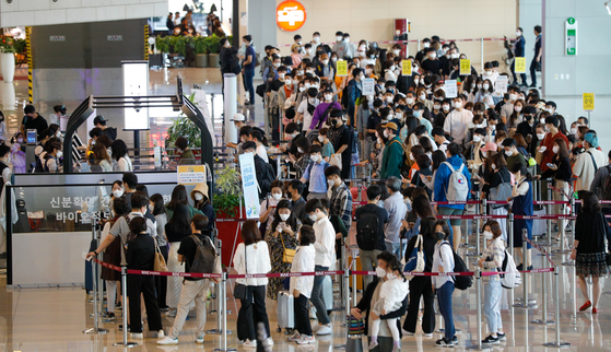 Travelers wait in long lines to board domestic flights at the departure terminal of Gimpo International Airport in Gangseo District, western Seoul, on Wednesday — Buddha’s Birthday and also a national holiday. [NEWS1]