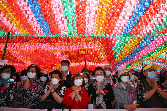 People pray at a service celebrating the 2,565th birthday of Buddha at Jogye Temple in Jongno District, central Seoul, on Wednesday. [OH JONG-TAEK]