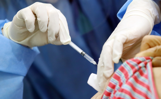 A medical staff vaccinates a citizen in central Seoul, Thursday. [YONHAP]