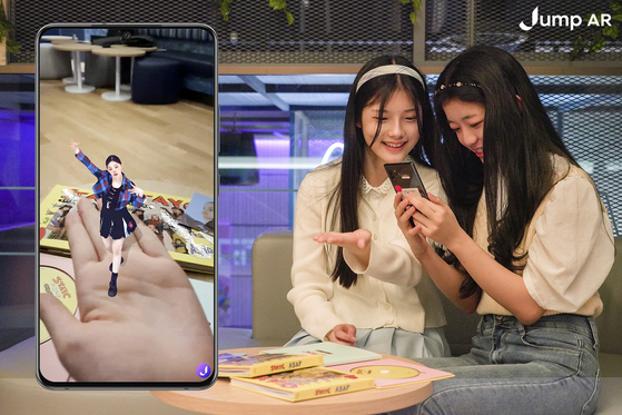 Models try out the ″digital human content″ AR service available on the Jump AR app created by SK Telecom, featuring girl group STAYC. The content has been created as a part of the telecom company's ″K-pop Metaverse Project.″ [SK TELECOM]