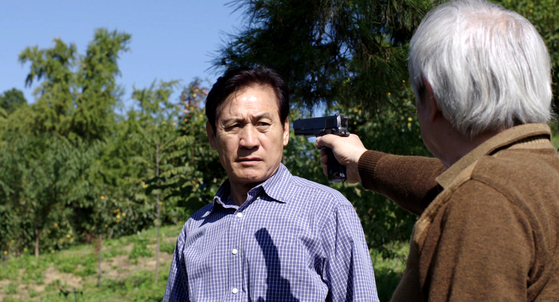 A scene from the film where Chae-geun is held at gunpoint as his identity is about to be uncovered. [ATNINE FILM]
