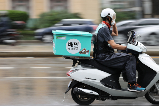 A Baedal Minjok food delivery rider in Seoul in 2020. The government started a program in which customers will get a 10,000-won refund for every four orders placed via food delivery apps to boost restaurant businesses hit by social distancing restrictions. [YONHAP]