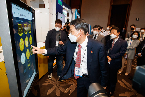 FSC Chairman Eun Sung-soo tests some of the fintech technologies exhibited at the Korea Fintech Week held at Conrad Hotel in Yeouido on Wednesday. [FINANCIAL SERVICES COMMISSION]