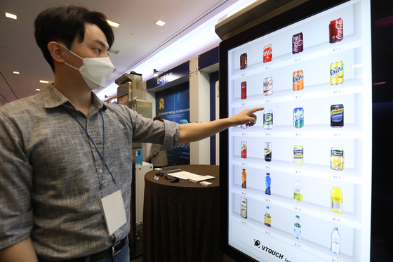 An employee demonstrates a digital vending machine during an invention event organized by the Korean Intellectual Property Office and the Korea Invention Promotion Association at the 63 Convention Center in Seoul on Monday. [NEWS1] 