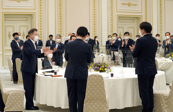 President Moon Jae-in, left, talks to the first-term lawmakers of the ruling Democratic Party at a Blue House meeting on Thursday. [YONHAP]