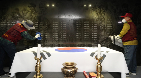 Workers disinfect the memorial monument in Suwon, Gyeonggi, on Thursday, so that visitors can safely pay their respects at the monument on Memorial Day on June 6. [NEWS1]