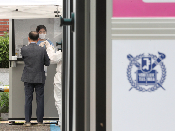 A faculty member from Seoul National University gets tested for Covid-19 at a rapid molecular testing center on campus on June 1. After expanding molecular Covid testing to all school members, Seoul National University plans to resume in-person classes this fall semester. [NEWS1]