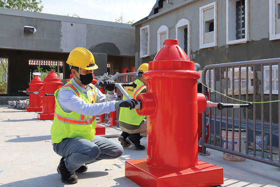 Workers at the Fire Academy set at Lego Land in Chuncheon, Gangwon, on Tuesday. According to Legoland Korea, 80 percent of the toy brick amusement park has been completed. The amusement park is set to open in the first half of 2022. [YONHAP]