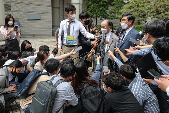 Lim Chul-ho, center, the son of a deceased forced laborer, speaks to reporters Monday afternoon about plans to appeal after the Seoul Central District Court dismissed a lawsuit by 85 Korean victims of wartime forced labor and their families against 16 Japanese companies, the largest of its kind. [YONHAP]