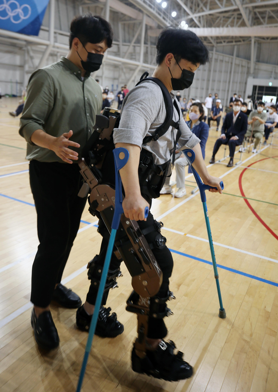 A visitor tries a wearable robot for the disabled during an event at Gangneung Yeongdong University in Gangneung, Gangwon, on Wednesday. The testing of the robot will take place between June and September at the university's physiotherapy simulation center. [YONHAP]