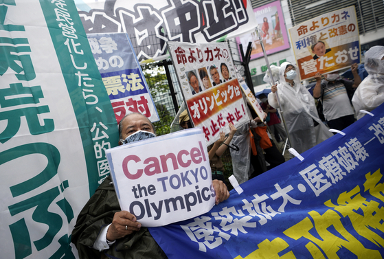 Protesters in Japan hold banners during a rally against the coming Tokyo Olympics Sunday, as the Japanese capital is still in a state of emergency and locals fear a further spread of Covid-19 with the arrival of thousands of athletes and staff from overseas. [EPA/YONHAP]