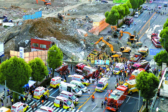 Firefighters work to remove the remains of a five-story building that collapsed on a city bus in Gwanjgu Wednesday afternoon. At least nine were killed and eight seriously injured in the accident.  [CHUNG JEONG-PIL]