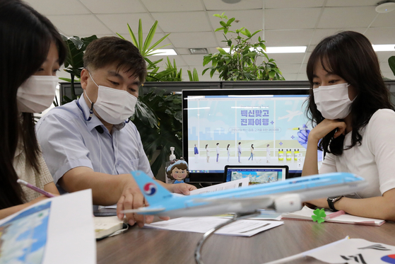 Travel agents at Very Good Tour discuss package tours at their offi ce in Jung District, central Seoul, on Wednesday. [NEWS1]