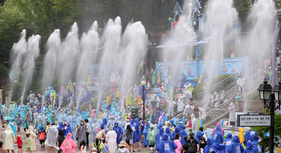 At the amusement park Everland in Yongin, Gyeonggi, on Tuesday, people enjoy getting doused with water cannons at the water festival “Shooting Water Fun.” [YONHAP]