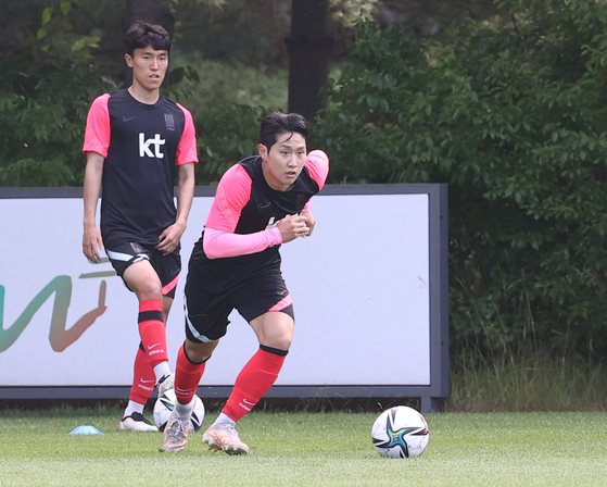 Lee Kang-in, right, runs with the ball at the National Football Center in Paju, Gyeonggi, on Wednesday. Lee and the rest of the U-23 squad have gathered at the center for a final training session before the squad for the 2020 Tokyo Olympics is announced next week. [YONHAP]