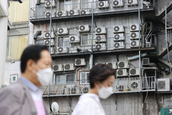 Air conditioners on the side of a building in Jung District, central Seoul on June 21. On the news of the government freezing electric bills again, Korea Electric Power Corporation shares tumbled 6.88 percent on June 21 compared to the previous session. [YONHAP]  