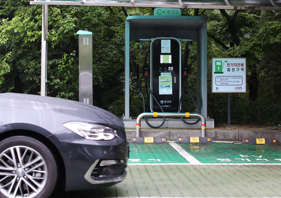 A car is parked in front of an electric car charger installed in Jongno District, central Seoul, on Sunday. According to the Ministry of Environment on Sunday, the charging price will be increased from 255.7 won ($0.23) per kilowatt-hour, the exact amount to be announced today. [YONHAP]
