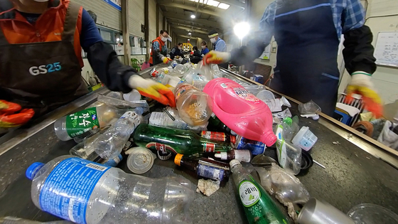 Recyclable waste being sorted out by workers at a center in Gimpo. [WANG JUN-YEOL]