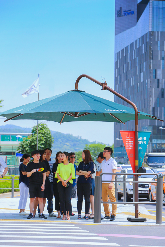 Large parasols strategically installed at pedestrian crossings during summer. [SEOCHO DISTRICT]