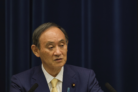 Japan's Prime Minister Yoshihide Suga speaks during a press conference at his residence in Tokyo, Thursday. Suga declared a fourth state of emergency would go in effect on Monday and last through Aug. 22. This means the Olympics, opening on July 23 and running through Aug. 8, will be held entirely under emergency measures.  [AP]