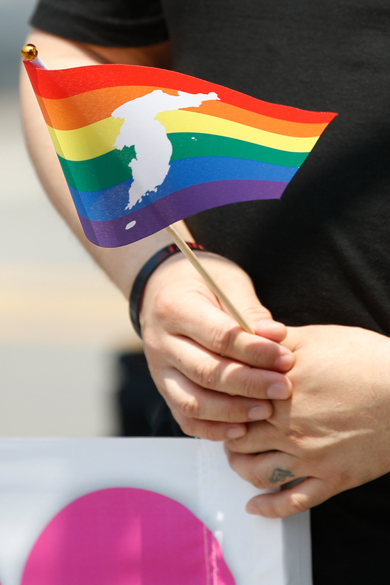 A participant holds a rainbow flag at the 2021 International Day Against Homophobia, Biphobia, Interphobia & Transphobia in Sinchon, western Seoul, on May 22. The event was held under the slogan ″We are here″ and urged the National Assembly to pass an anti-discrimination law this year. [NEWS1]