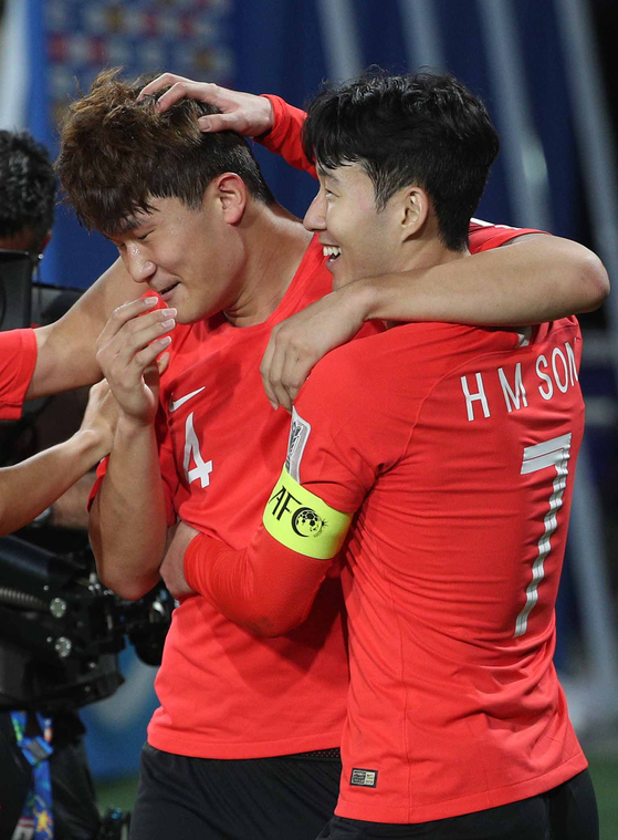 Son Heung-min, right, and Kim Min-jae celebrate after Kim scored a goal for Korea in a game against China at the 2019 AFC Asian Cup in the United Arab Emirates on Jan. 16, 2019. [NEWS1]