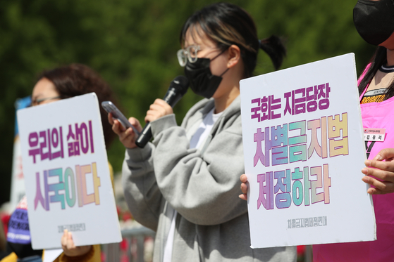 A coalition of women's rights organizations holds a protest outside the National Assembly in western Seoul on May 26 to urge the establishment of an anti-discrimination law. [YONHAP]