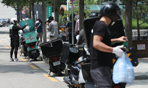 Delivery rider motorcycles are parked in Mapo District, western Seoul, on Monday. Monday was the first day of stricter social distancing measures, and food deliveries surged as many stayed indoors to eat. [YONHAP]