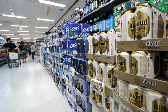 Visitors at a supermarket in Seoul look at alcohol beverages on Wednesday. Sales of wine, beer and makgeolli are rising at supermarkets and convenience stores as more people opt to stay home and drink alone amid the intensified social distancing scheme. [NEWS1]