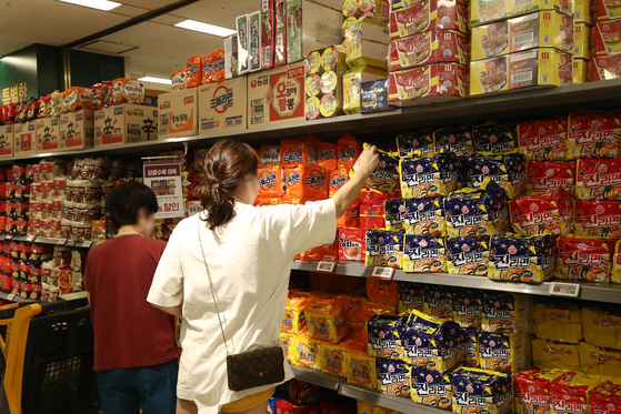A customer picks up Jin Ramen in the ramyeon section of a supermarket in central Seoul on Thursday. Ottogi said Thursday it will raise the price of Jin Ramen, along with other products, starting Aug. 1. [YONHAP]