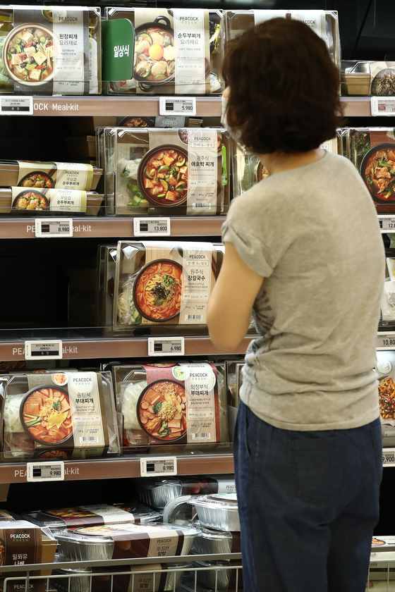 A customer looks at meal kits at a supermarket in Seoul on Thursday. Stricter distancing guidelines have forced people to stay home longer and resulted in an increase of demand for meal kits. [YONHAP]