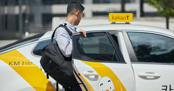 A passenger gets in a Kakao Blue taxi. [KAKAO MOBILITY]