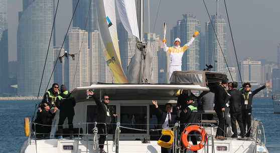 Ha Jee-min holds the 2018 PyeongChang Winter Olympics torch on a yacht at Yongho Sightseeing Boat Quay in Busan on November 6, 2017. [JOONGANG ILBO]