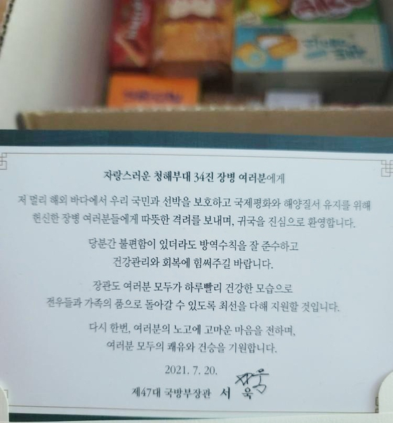 In this photo, a box of snacks sent by Defense Minister Suh Wook to a Covid-19-infected member of the Cheonghae Unit is seen with a letter.  [Provided by the Cheonghae Unit sailor]