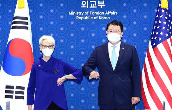 South Korean First Vice Foreign Minister Choi Jong-kun, right, and U.S. Deputy Secretary of State Wendy Sherman bump elbows ahead of talks at the Foreign Ministry in central Seoul, Friday. [FOREIGN MINISTRY]