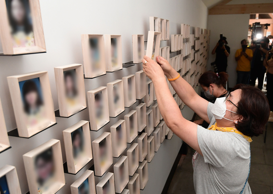 Family members of victims of the 2014 Sewol ferry disaster relocate photos of their children and loved ones from a memorial hall at Gwanghwamun Square to a makeshift hall on the first floor of Seoul Metropolitan Council on Tuesday. The memorial hall for Sewol victims was demolished after the relocation due to reconstruction of the square currently under way. [NEWS1]