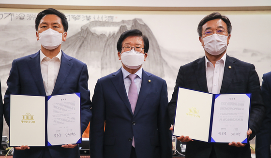 Rep. Kim Gi-hyeon, floor leader of the main opposition People Power Party, left, and Rep. Yun Ho-jung, floor leader of the ruling Democratic Party, right, hold agreements at the office of National Assembly speaker Park Byeong-seug, center, on Friday. They struck a deal that day that the ruling party will end its control of all 18 National Assembly committees and allow the opposition to chair seven in the final two years of the 21st National Assembly. [YONHAP]