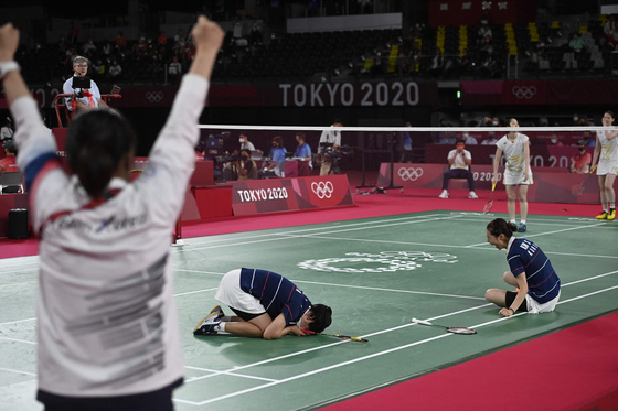 Kong Hee-yong (center) and Kim So-yeong (right) celebrate as their coach cheers after winning their women's doubles badminton quarterfinal. [AFP/YONHAP]