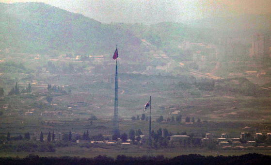 The flag of South Korea, right, and the flag of North Korea, left, stand close together in a border area between the two Koreas on July 27. [YONHAP]