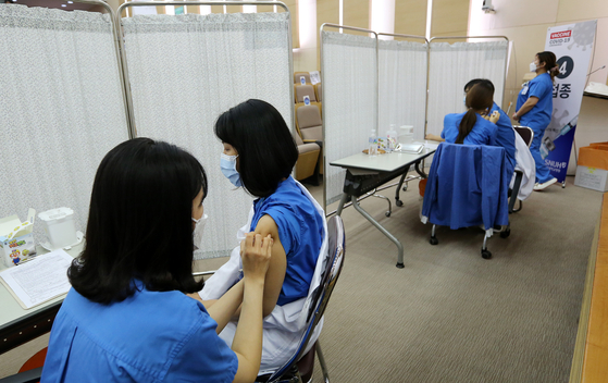 In this file photo, doctors, nurses and nursing assistants of the Seoul National University Hospital receive AstraZeneca shots on March 5, 2021. The hospital vaccinated its 8,300 workers in March.  [NEWS1] 