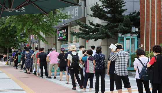 People wait in line to apply for unemployment allowances at an employment center in Nowon District, northern Seoul, on Monday. The Covid-19 pandemic has led to the loss of many jobs. [YONHAP]