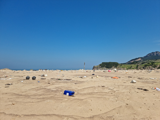 Garbage litters the sand on July 20 after the tide ebbed on Mokkimi Beach, Guleop Island. [SHIM SEOK-YONG]